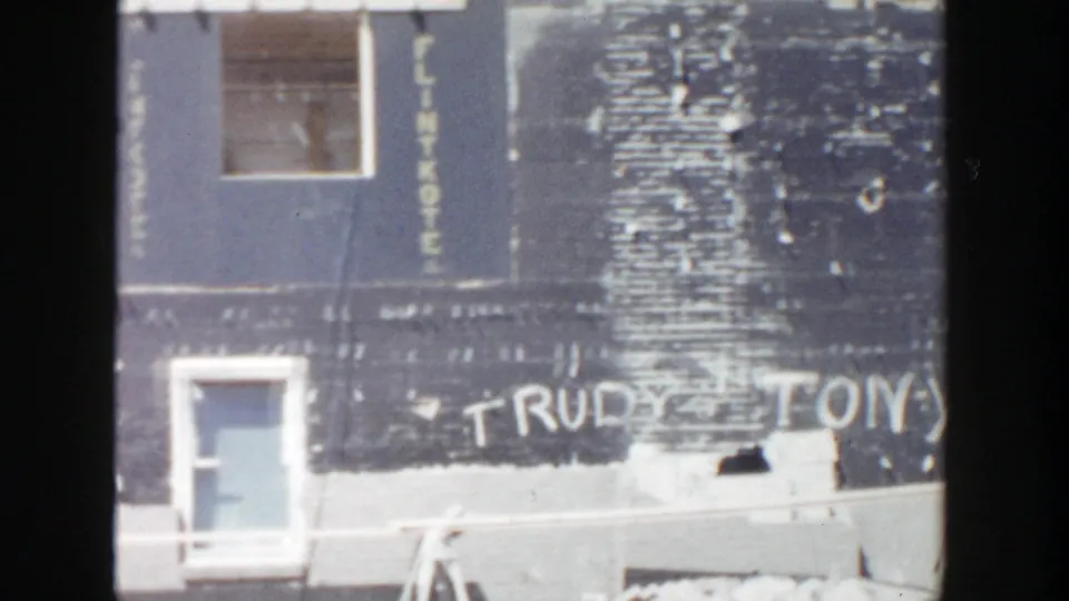 1956 Grand Rapids construction wall with a doorway, white Trudy Tony graffiti, and vertical lettering that appears to read Flintkote.