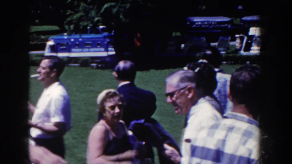 The 1958 French Lick scene shows adults conversing on a lawn as an older man smiles and a blue bus remains visible behind them.
