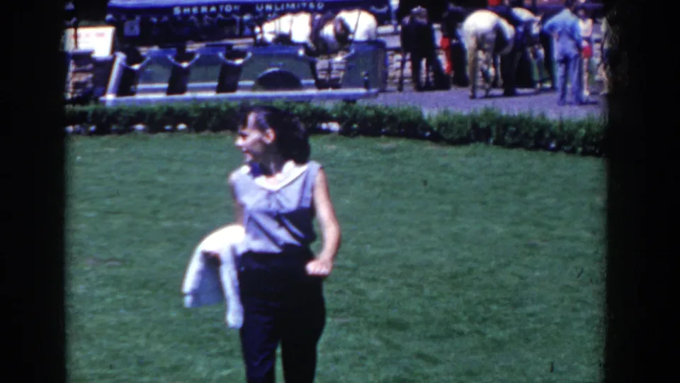 A woman in sleeveless clothing is seen on the lawn at French Lick, with resort guests and a Sheraton Unlimited sign in the background.