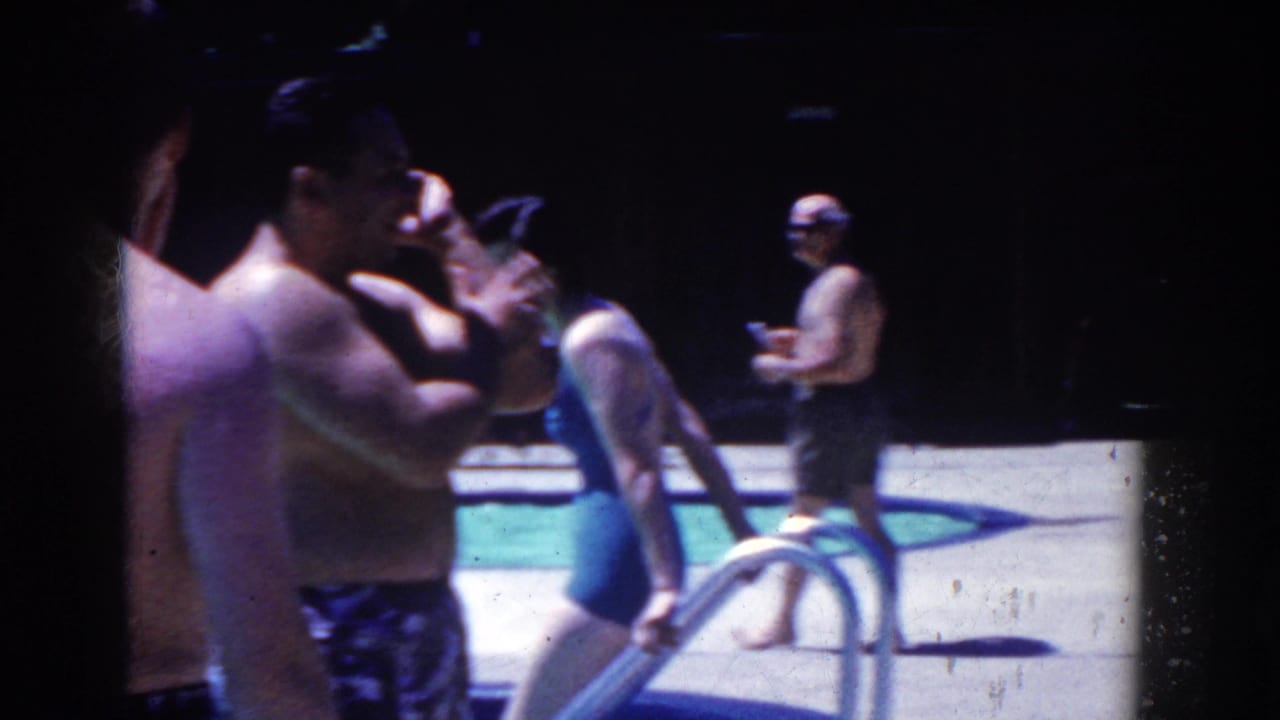 French Lick, Indiana 1958 home-movie frame showing adults in swimsuits by an outdoor pool ladder and concrete deck.