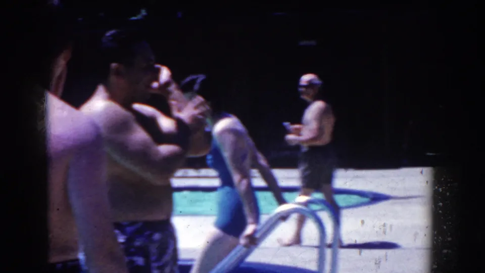 French Lick, Indiana 1958 home-movie frame showing adults in swimsuits by an outdoor pool ladder and concrete deck.