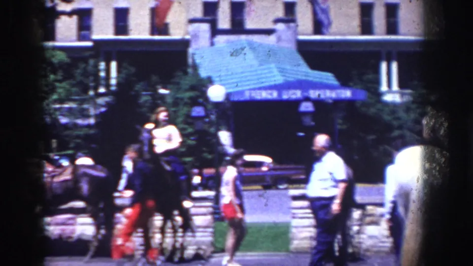 1958 French Lick street view showing a horseback rider and pedestrians near the French Lick-Sheraton entrance.