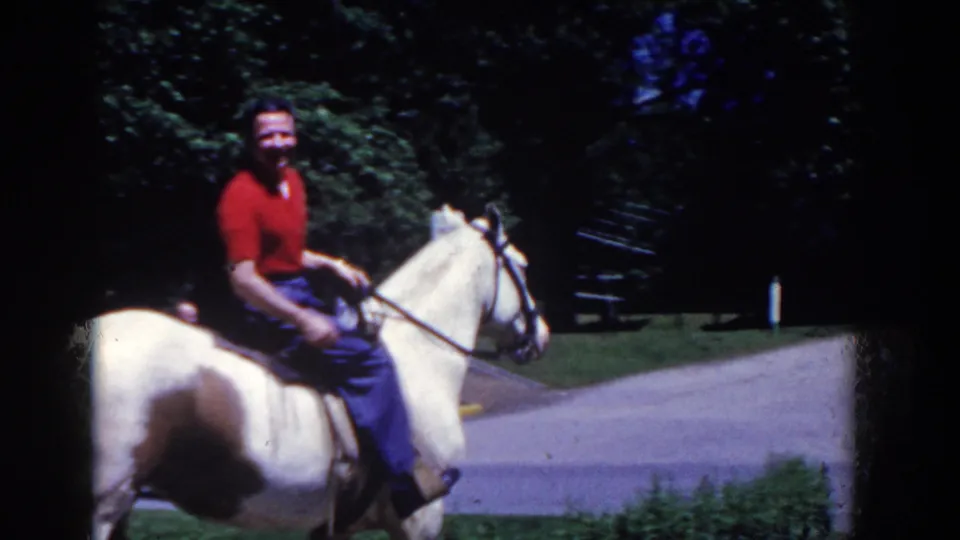 A rider in a red shirt appears on the pinto horse near a park road in the 1958 French Lick, Indiana home movie.