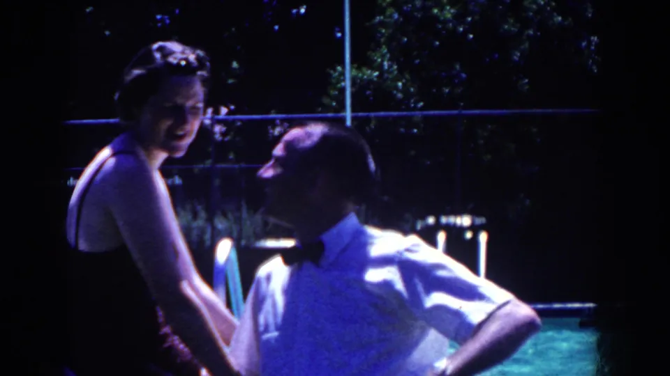 At the end of the 1958 French Lick clip, the woman smiles toward the camera while the man turns toward her beside the pool.