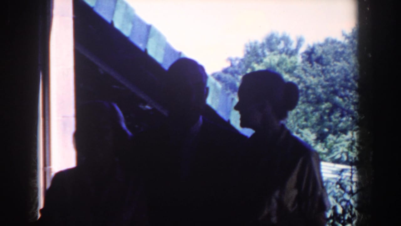 A backlit doorway scene shows several adults in silhouette, including a woman in profile, during the 1958 French Lick home-movie clip.