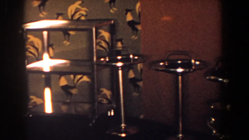 Gold-toned ashtrays and a trophy-like object are arranged on a table in a 1958 French Lick interior.