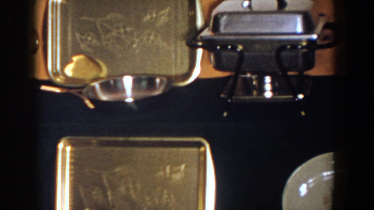Silver trays and a chafing dish arranged on a dark surface.