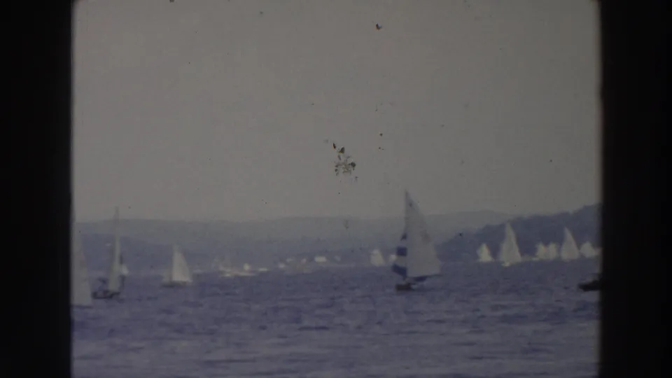 1960s Wisconsin lake scene with several sailboats at varying distances on rippled water.