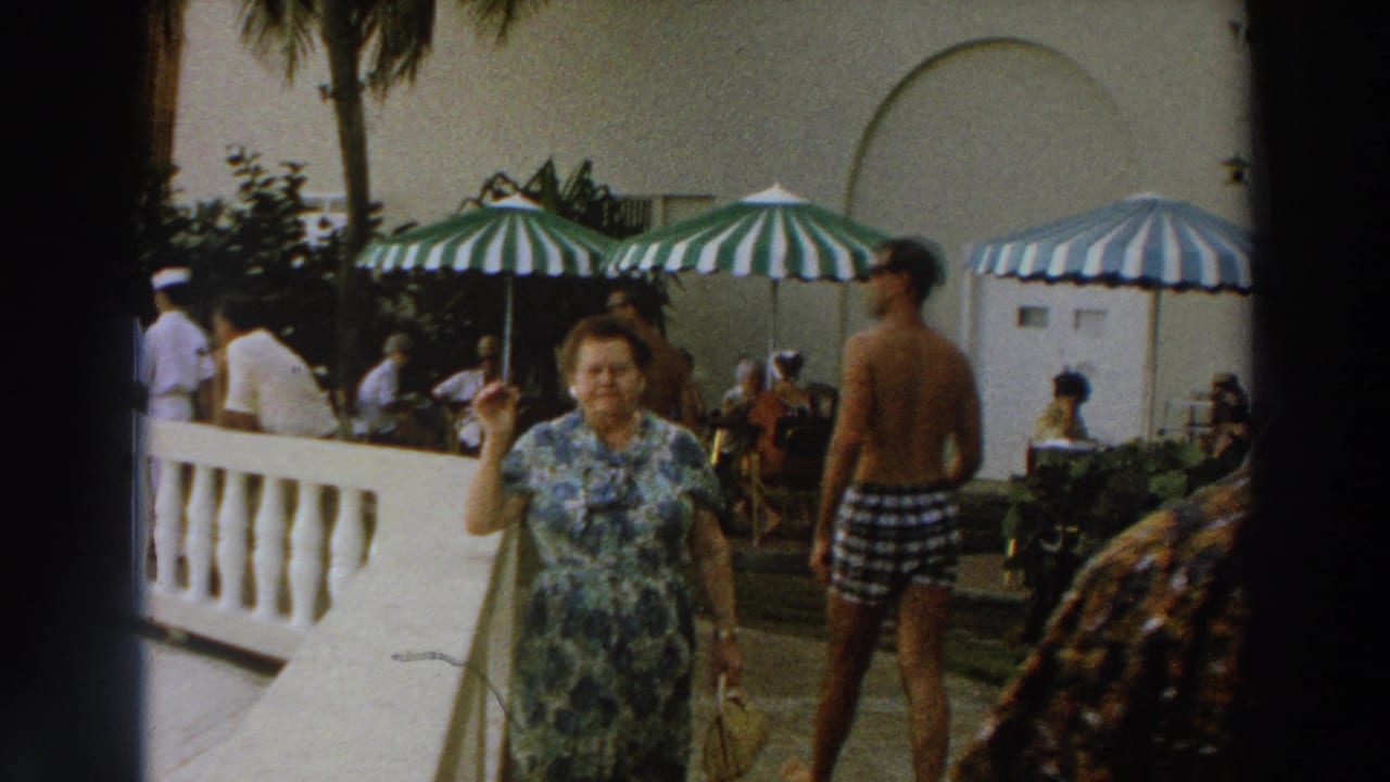 1966 Wisconsin patio scene with a woman in a floral dress raising her hand as resort guests move behind her.
