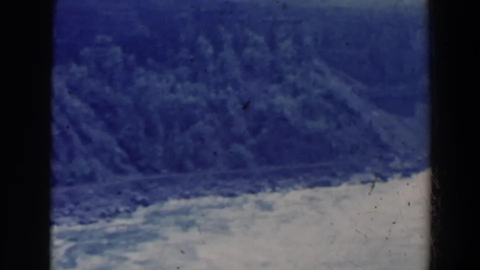 1963 8mm view near Niagara Falls, Canada, showing a river gorge, wooded slope, and dark vertical frame edge.