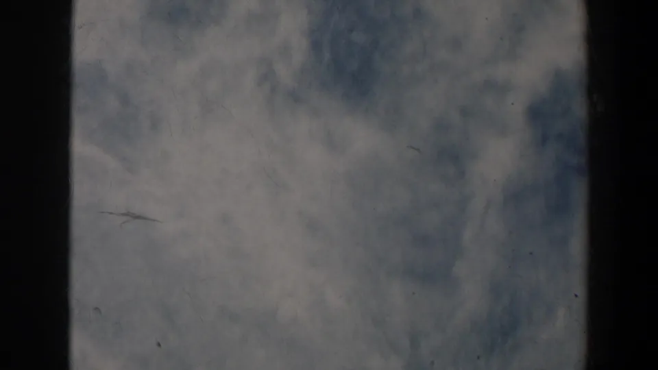 Soft 1963 8mm frame showing pale haze or sky-like texture between dark film-strip borders.