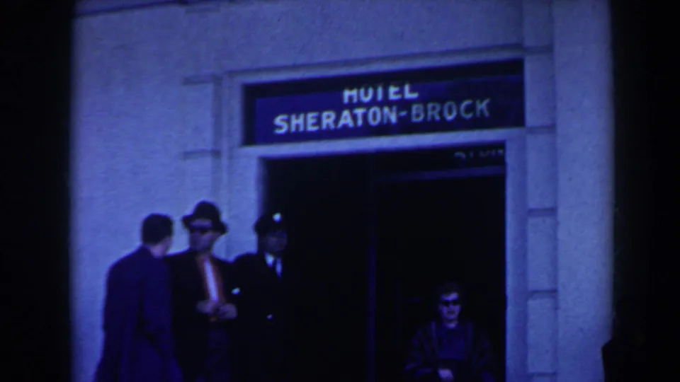 1963 Niagara Falls hotel entrance scene showing people near the Hotel Sheraton-Brock sign and shadowed doorway.