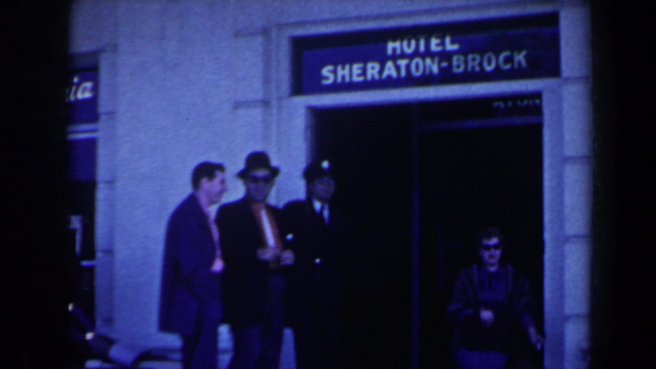 1963 Niagara Falls, Canada home-movie frame showing travelers outside the Hotel Sheraton-Brock entrance with a cafeteria sign nearby.