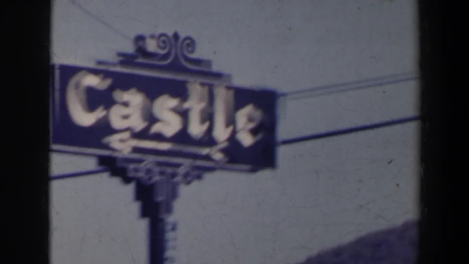 Soft-focus 1963 Niagara Falls frame of the Castle sign filling much of the view, with the sign post and utility wires visible.
