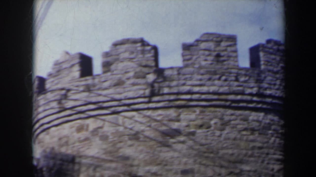 1963 Niagara Falls, Canada home-movie frame showing a round crenelated stone tower with weathered masonry and dark film borders.