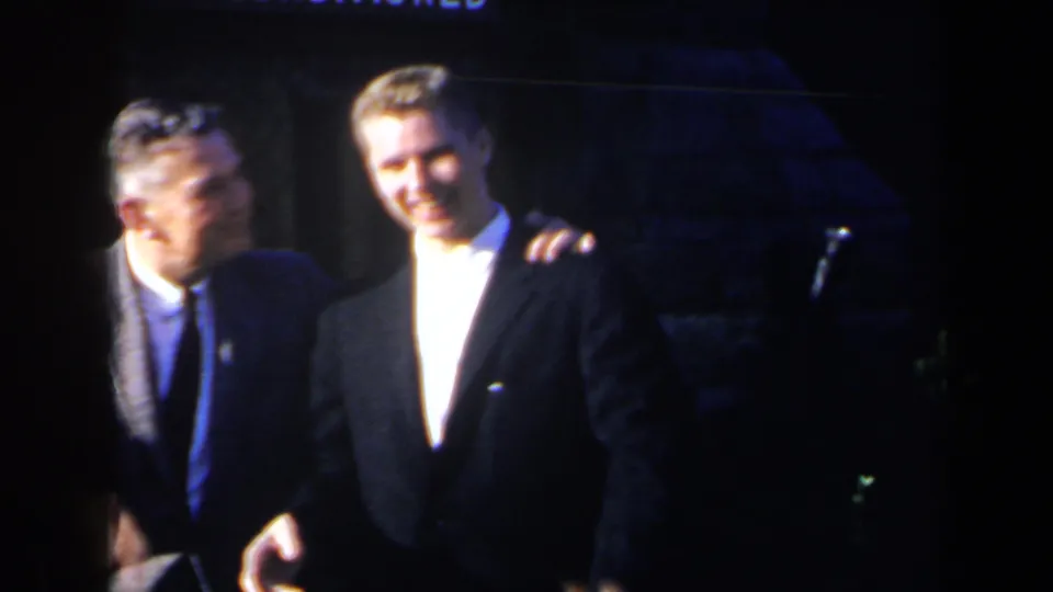 The men stand side by side after the greeting, one placing an arm near the other's shoulder in a friendly stage moment.