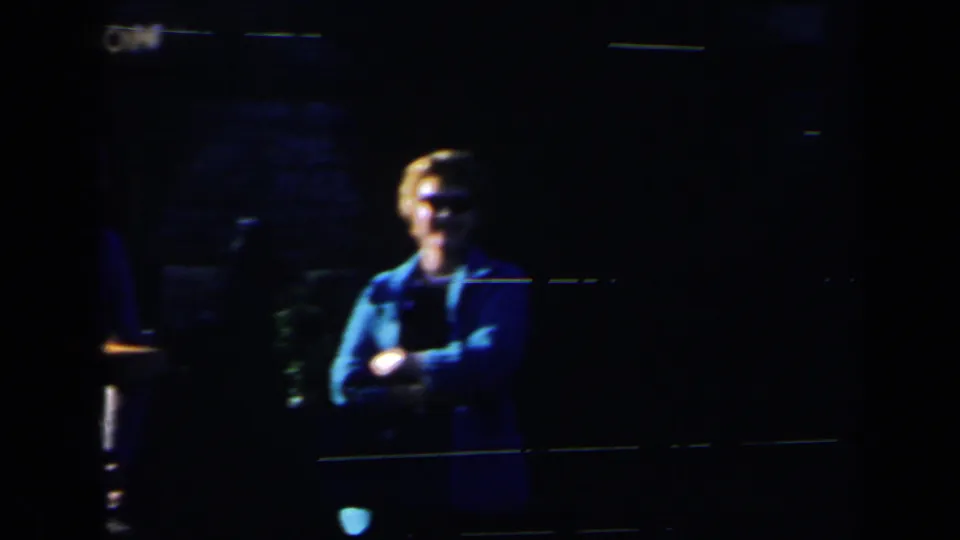 The final frame shows a woman in sunglasses and a blue jacket, partly isolated by deep shadow in the 1963 home-movie footage.