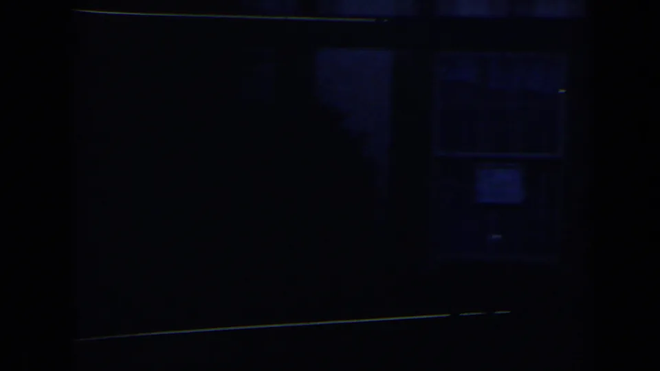 Underexposed 8mm frame from the Niagara Falls clip showing a dark entrance area with little visible activity.