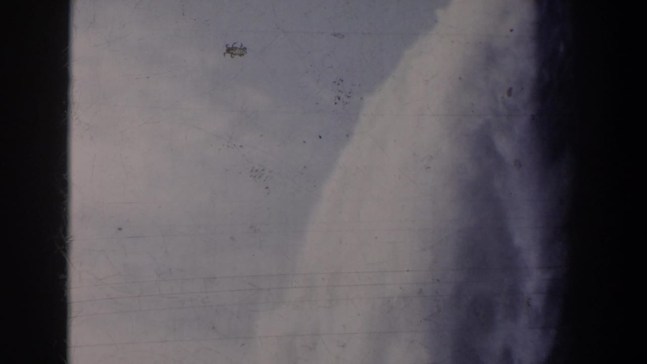 1963 8mm view at Horseshoe Falls, with pale mist, rushing water forms, scratches, and dark film-gate borders.
