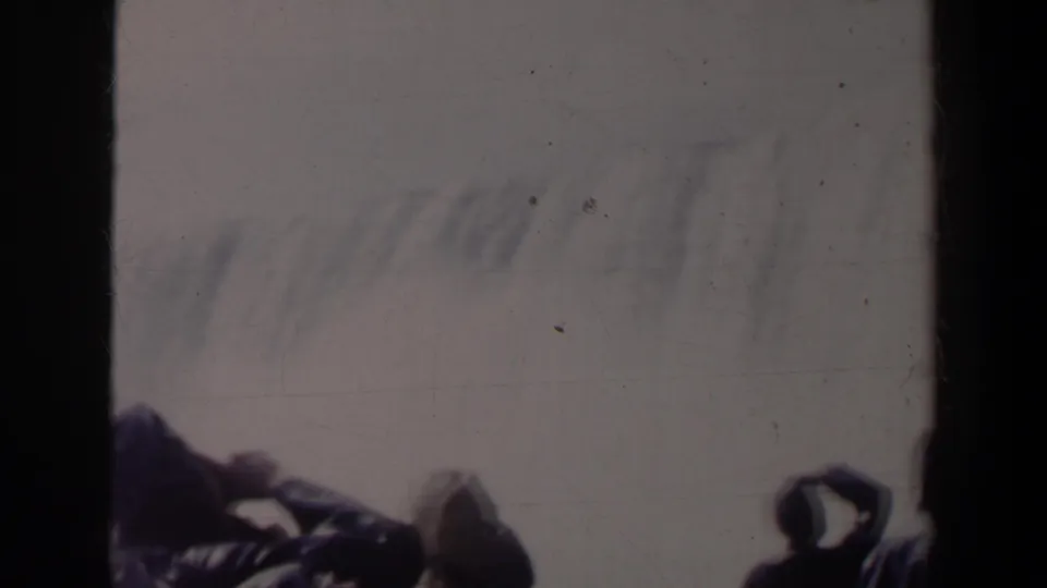 1963 8mm view at Niagara Falls, Canada, with dark silhouetted visitors leaning near a railing against mist and pale sky.