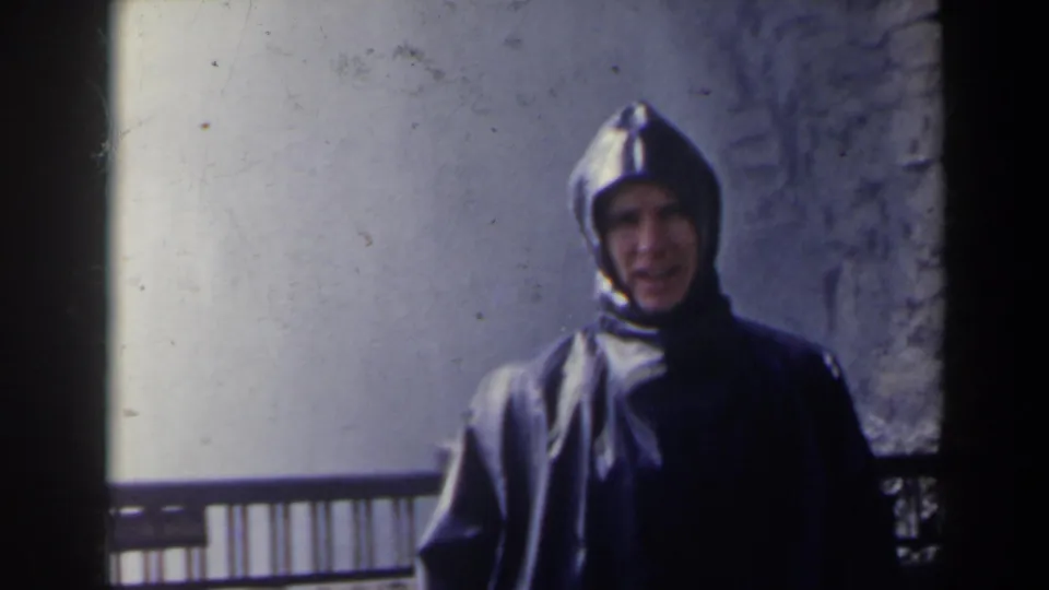 A closer 1963 Niagara Falls view shows the hooded man in rain gear near the railing, with bright mist or waterfall surface behind him.