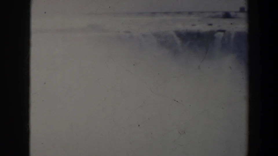 Final 1963 Niagara Falls frame with heavy mist, a partial waterfall section at right, and soft 8mm film texture.