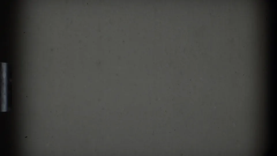 A softly exposed 8mm frame showing a dark kitchen cabinet or appliance surface and a small vertical metal handle.