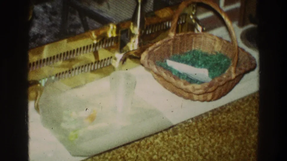 Final frame of the 1969 Clarendon Hills clip holds on the Easter basket and tray arrangement in a private home interior with warm faded 8mm color.