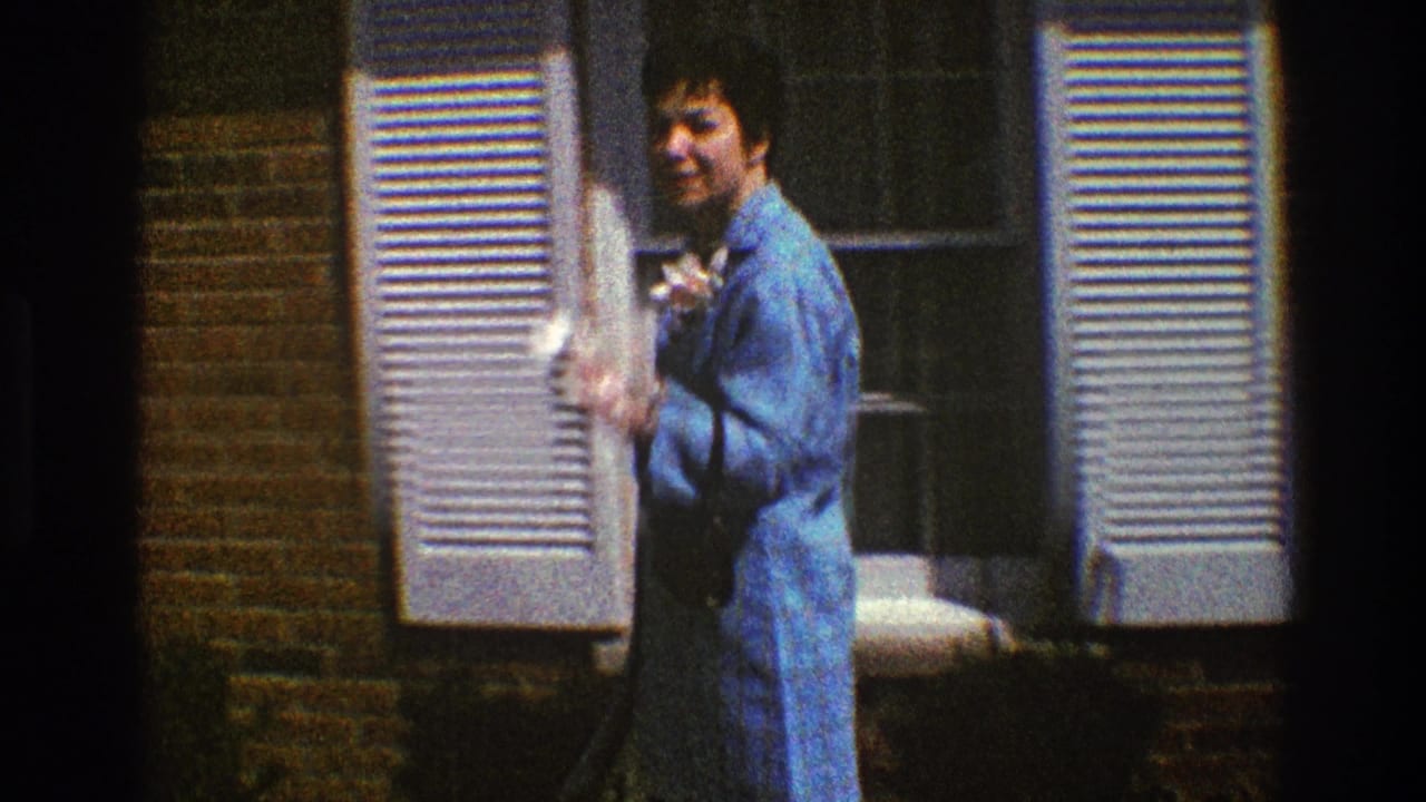 The woman turns toward the camera near a shuttered window on a brick house exterior in Clarendon Hills, Illinois.