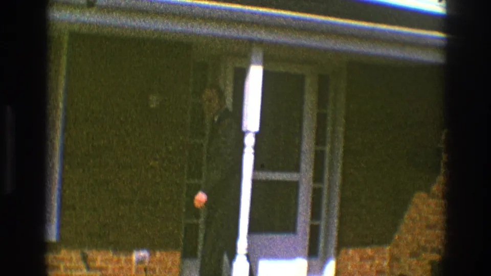 The man is partly obscured as he moves through the doorway of the Clarendon Hills brick home, filmed on 8mm in 1969.