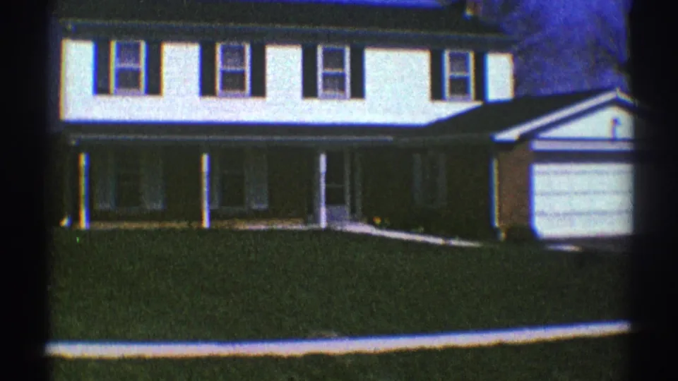 A white two-story suburban house with dark shutters and a garage appears in Clarendon Hills, Illinois, in 1969.