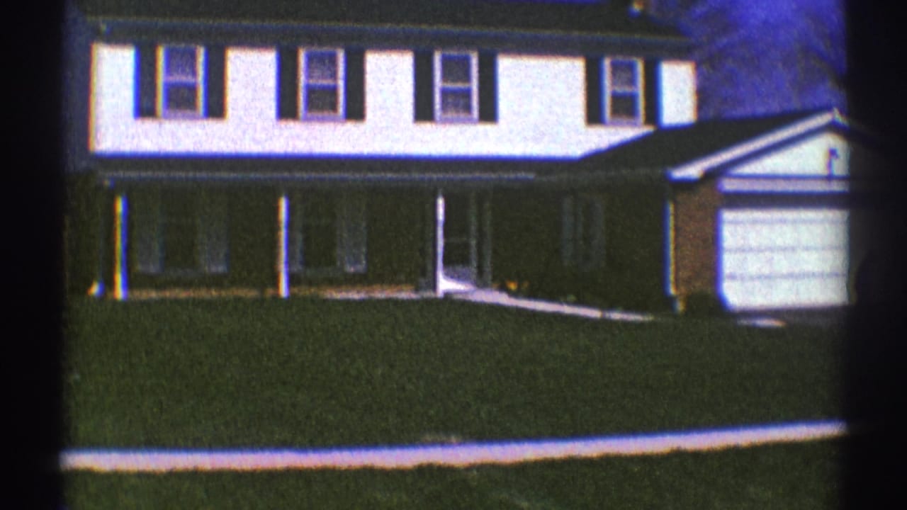 1969 Clarendon Hills frame with the house facade, covered porch, lawn, garage, and a small person near the garage area.