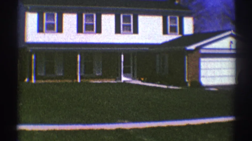 1969 Clarendon Hills frame with the house facade, covered porch, lawn, garage, and a small person near the garage area.