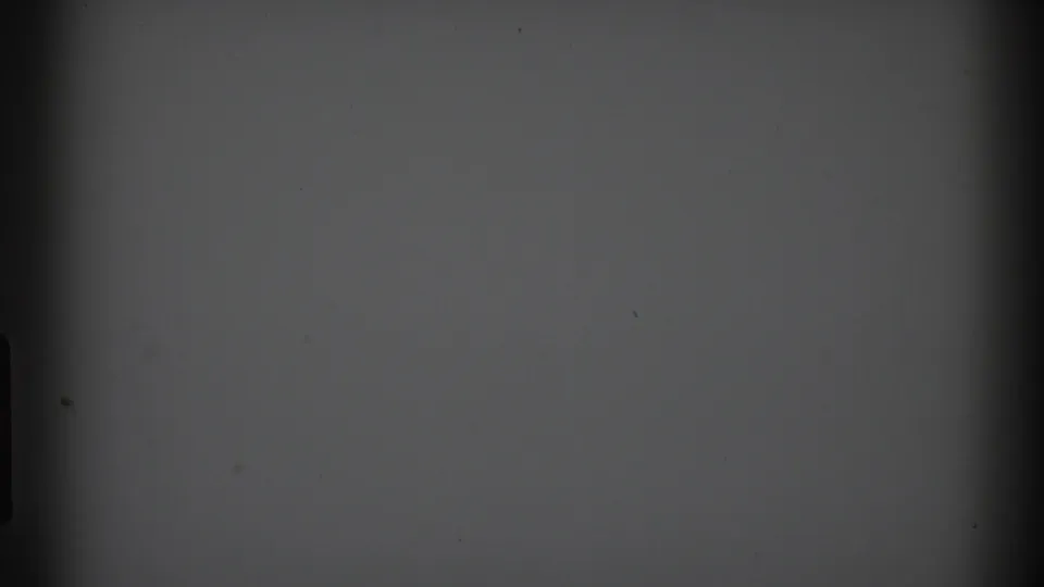 1969 Clarendon Hills 8mm frame with a nearly blank gray screen, dark vertical borders, central shadowing, and minor dust marks.