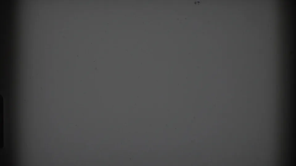 1969 Clarendon Hills 8mm frame showing a blank gray screen with dark gate edges, faint horizontal banding, and small dust specks.