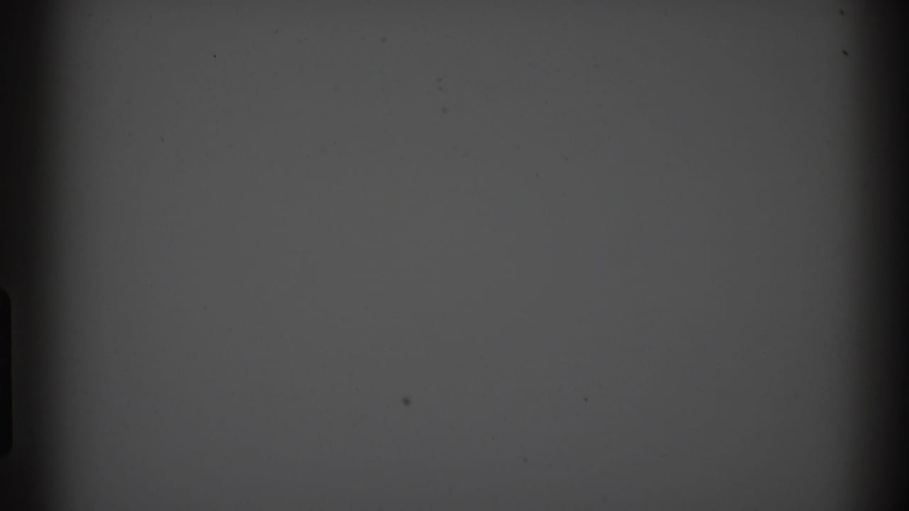 Mostly dark 8mm frame with gray upper exposure and little visible subject detail.