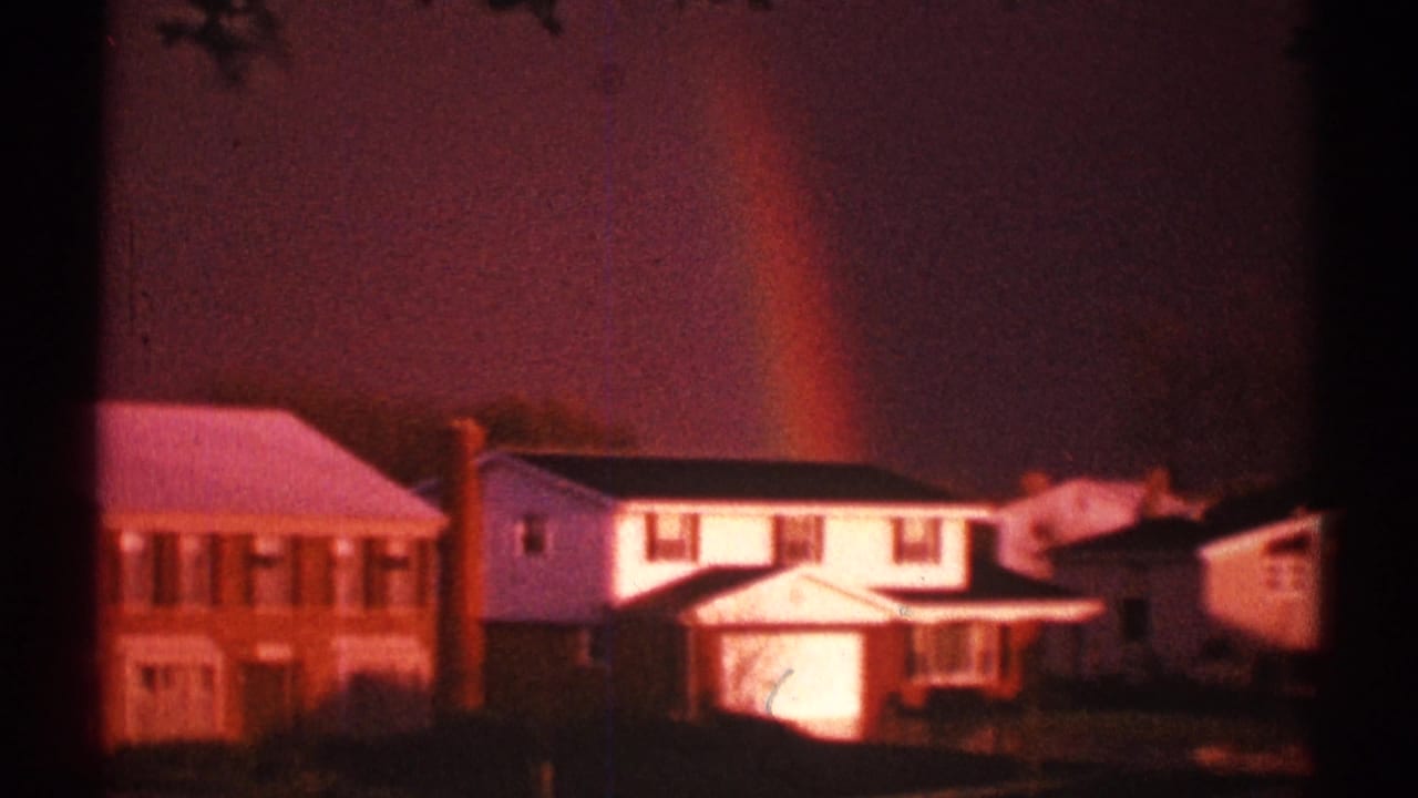 Two-story suburban houses beneath a faint rainbow in a purple sky.