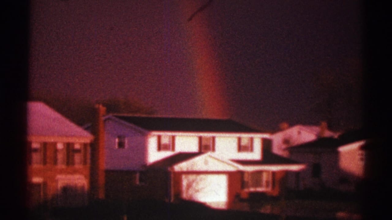 Clarendon Hills, Illinois frame with a rainbow behind a white two-story house and adjacent brick residences.