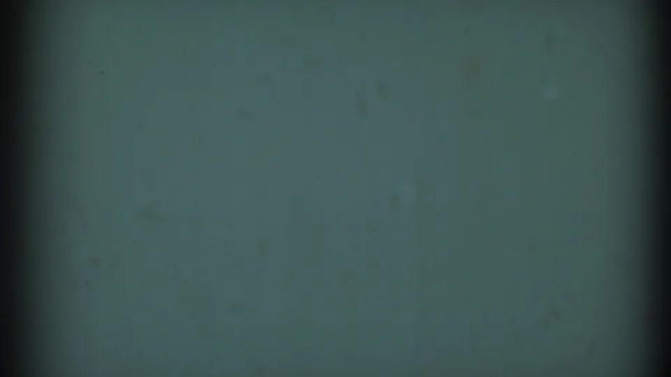 1969 8mm frame from the Clarendon Hills clip showing a muted green-blue field, vertical scan or gate shadow, soft vignetting, and dust.