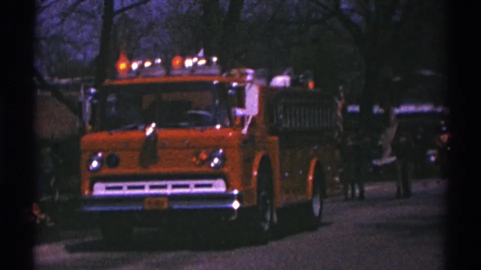 A closer 1969 view shows the orange fire truck passing the camera on a shaded residential street in Clarendon Hills.
