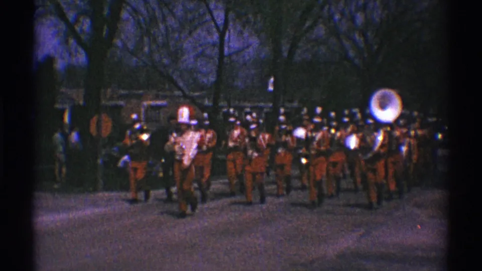 A uniformed marching group follows the fire truck on the Clarendon Hills street, including a visible sousaphone player.
