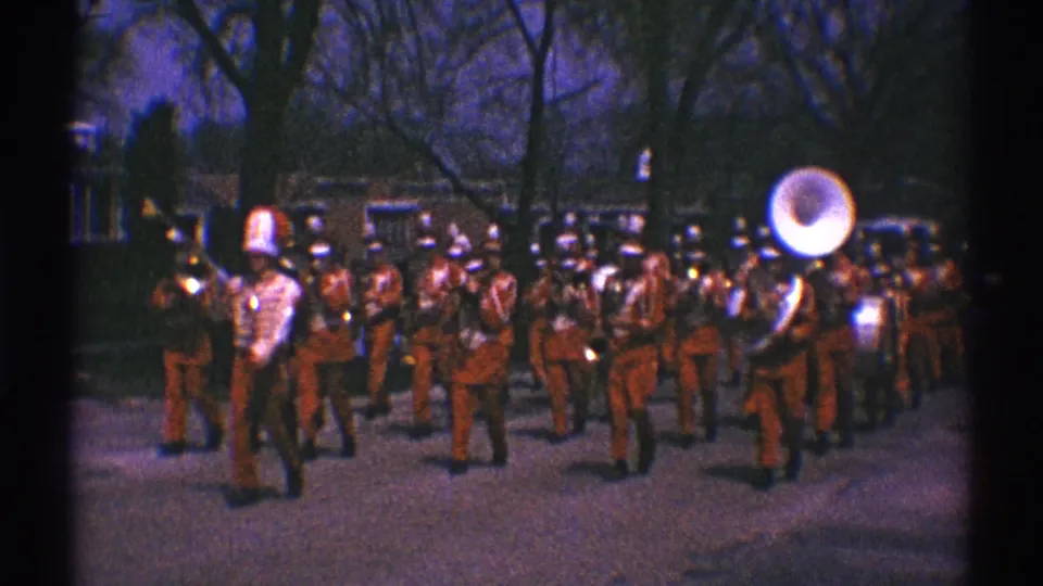 Clarendon Hills 1969 frame with band members in red uniforms and white hats, including a prominent sousaphone on the right.