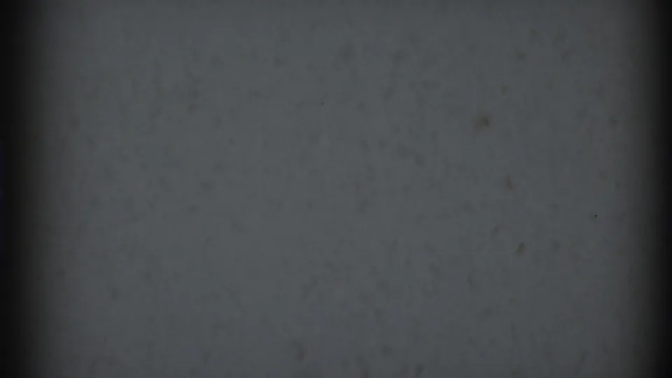 Blank reel-start frame from the 1969 Clarendon Hills 8mm clip, with dim gray-green texture, gate shading, grain, and specks.