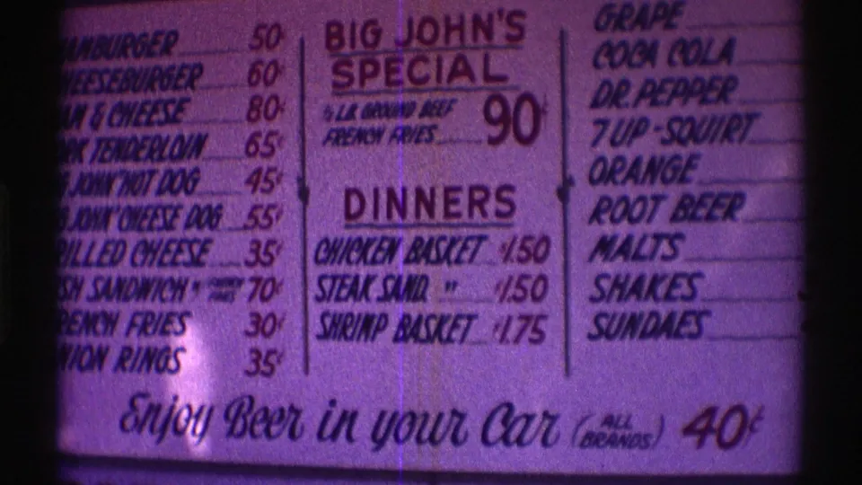 Final 8mm frame of the Nebraska menu board, with Big John's Special, dinner prices, and branded soft drink names visible.