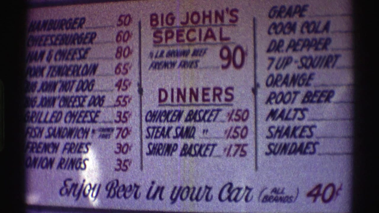 1969 Nebraska frame of the menu board emphasizing Big John's Special, chicken and shrimp baskets, soft drinks, and beer in your car for 40 cents.