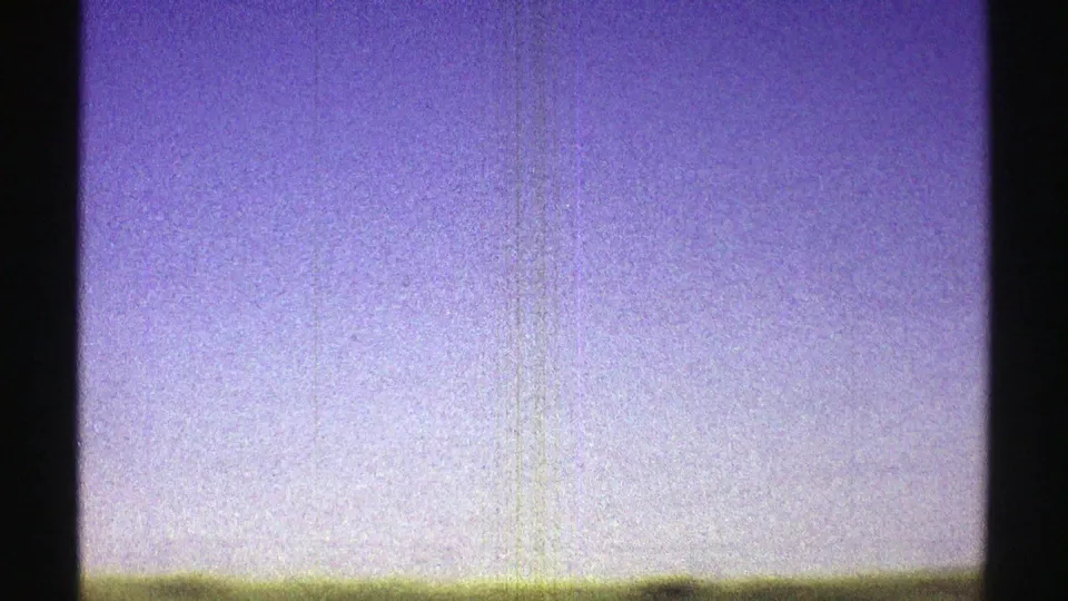 1969 Nebraska frame dominated by pale sky, with a narrow green rural horizon along the lower edge.
