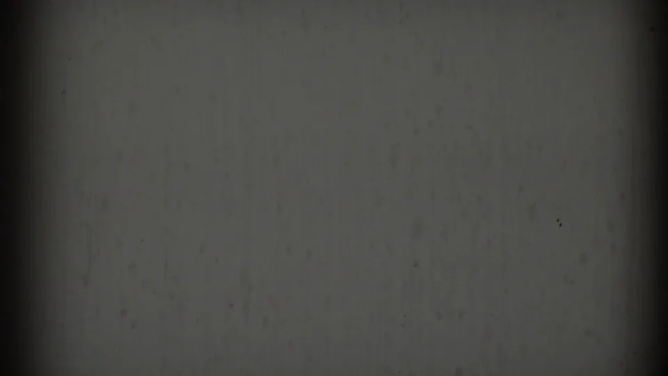 1969 8mm frame from Clarendon Hills metadata showing an abstract gray textured surface with dark vertical shadow bands and film specks.