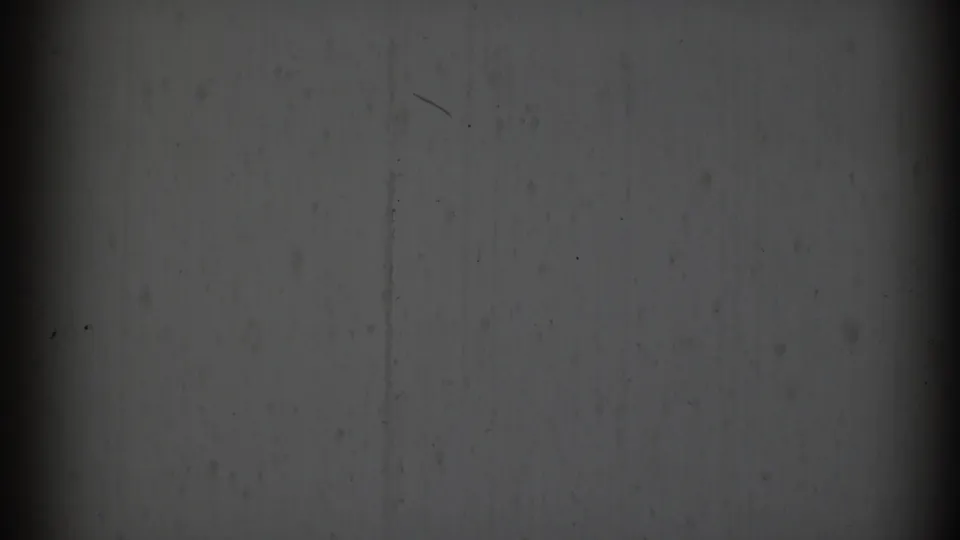 Abstract 8mm frame supported as 1969 Clarendon Hills footage, showing gray texture, a faint horizontal divide, dark vertical bands, and speckling.