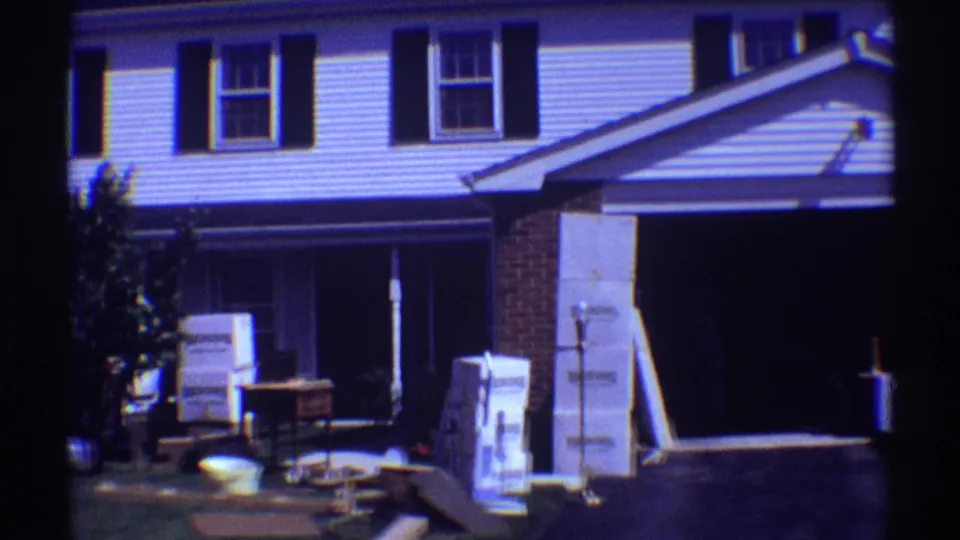 Clarendon Hills, Illinois house exterior with stacked moving boxes, small furniture, and an open garage area in 8mm home-movie footage.