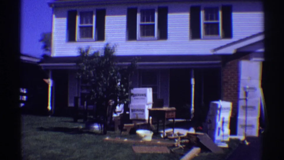 1969 suburban Illinois home exterior showing a front lawn, small tree, boxes, and furniture set outside during a move or renovation.